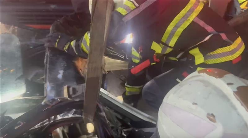 消防人員動用破壞器材撐開變形車體將受困駕駛救出。（圖／翻攝畫面）