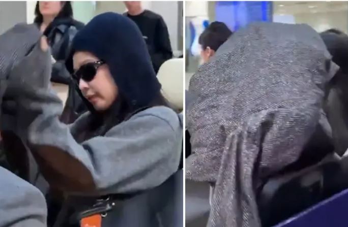 Jennie抵達桃園機場後突然擺臭臉用大衣蓋住全身。（圖／翻攝自X）