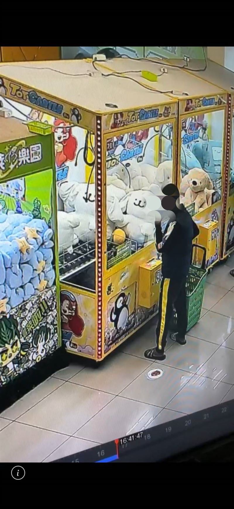 男子站在娃娃機台前，時不時吸食手中的物品，因為只有短短幾秒鐘，店員也難從認定吸的是什麼。（圖／翻攝畫面）