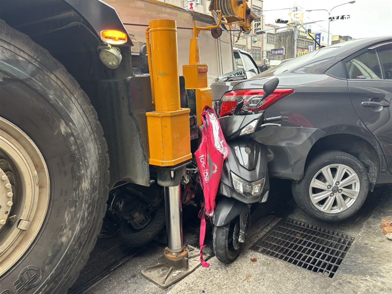 機車慘遭夾擊，外送箱慘遭壓扁變形，外送員奇蹟生還。（圖／翻攝畫面）