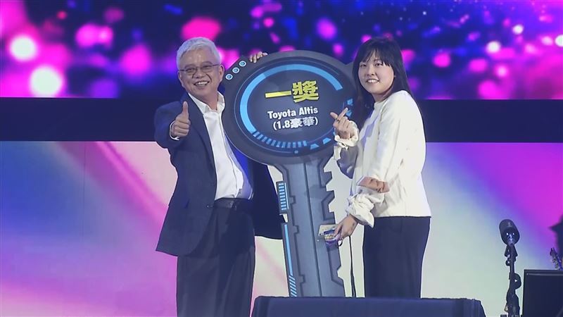 抽到頭獎的員工開心上台「領車」，讓台下同事羨慕不已