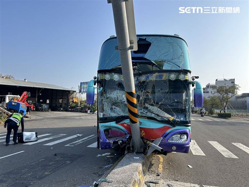一輛公司交通車擦撞機車後失控撞上分隔島，號誌桿「剖半嵌入」車頭。（圖／翻攝畫面）
