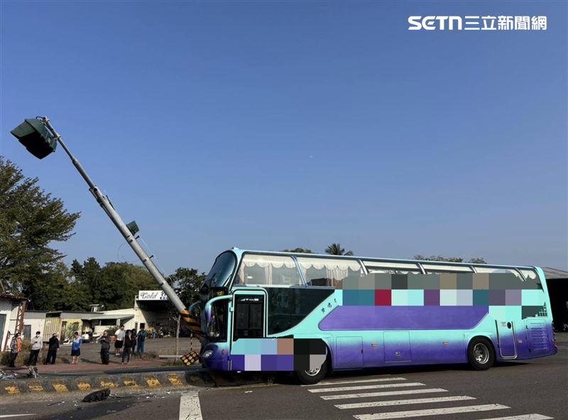 一輛公司交通車擦撞機車後失控撞上分隔島，號誌桿「剖半嵌入」車頭。（圖／翻攝畫面）