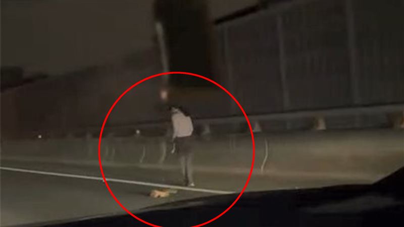 步行女子回頭撿掉落的包包，讓人相當擔心被來車撞上。（圖／翻攝記者料網）