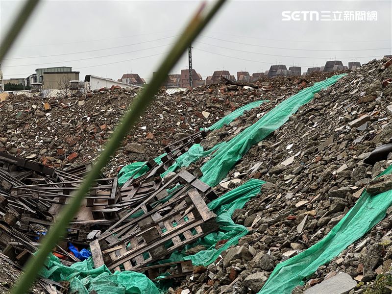 堆置的廢土並沒有完整覆蓋，靠近鐵絲圍籬就可以看見各種廢棄物。（圖／記者王乙徹攝影）