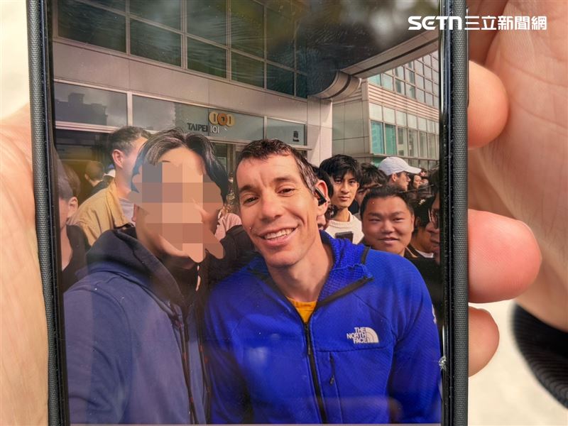 民眾興奮地秀出剛剛霍諾德休息空檔時與他的合照。(圖/記者簡浩正攝影)