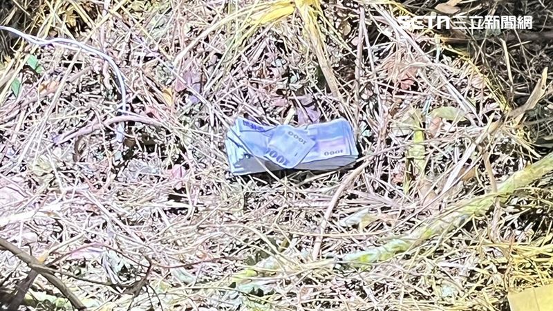 國道警方獲報展開地毯式搜索一無所獲，反而在草叢找到遺留的2大疊千元大鈔，共20萬元現金。（圖／民眾提供）
