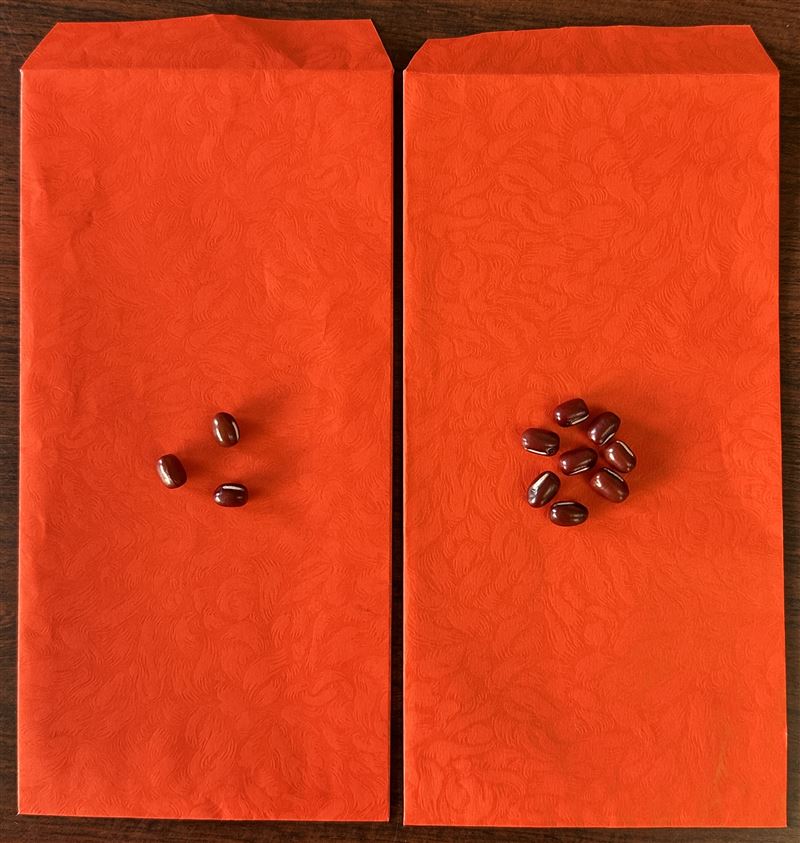 參加尾牙時可準備開運紅包兩個，一個放3顆紅豆、一個放8顆，分置口袋或錢包，紅色加持財運，數字3與8匯集木的能量。（圖／命理專家楊登嵙提供）