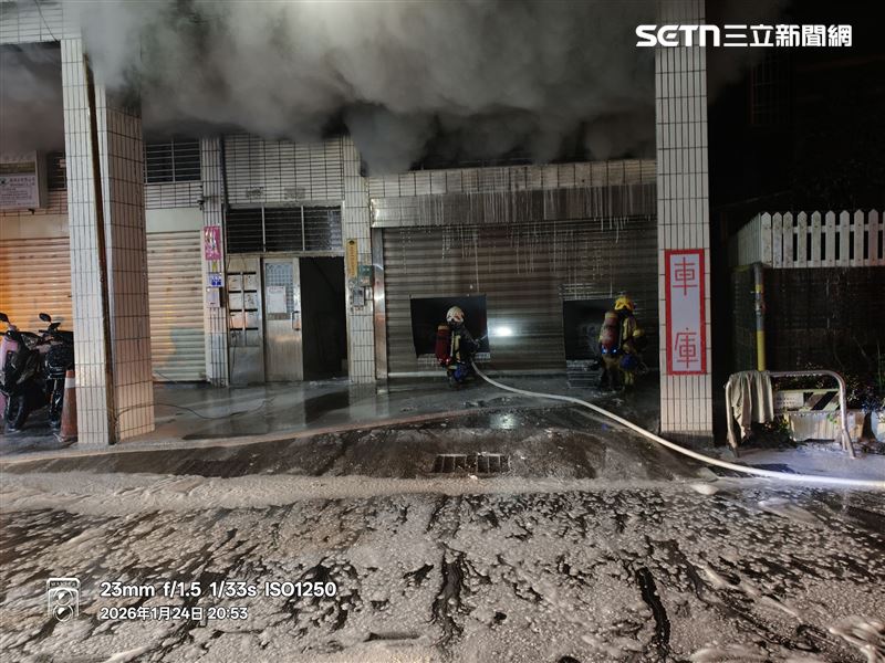 消防人員破門灌救，確認起火點為內部停放車輛。（圖／翻攝畫面）