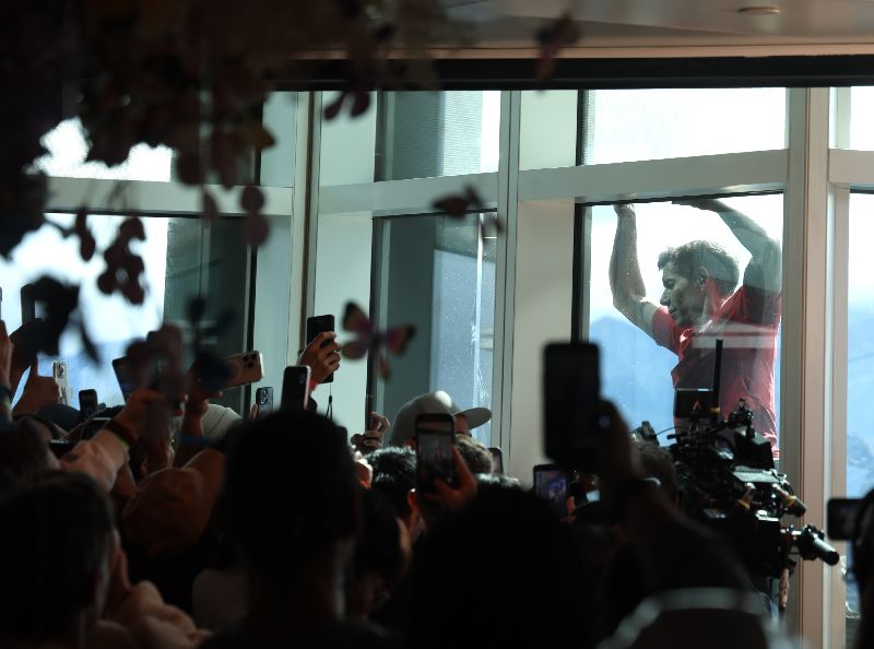 許多民眾在89樓觀景台為霍諾德加油打氣,拿起手機拍攝紀錄。(圖/中央社)