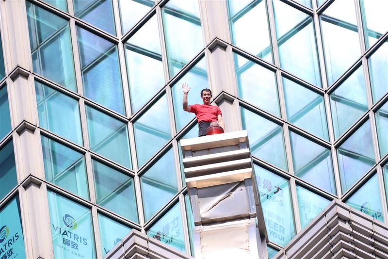 霍諾德攀爬101跟民眾揮手。（圖／記者鄭孟晃攝影）