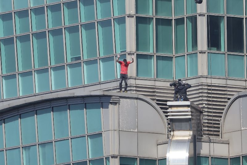 挑戰獨攀台北101過程中,霍諾德不時與底下民眾揮手致意。(圖/中央社)