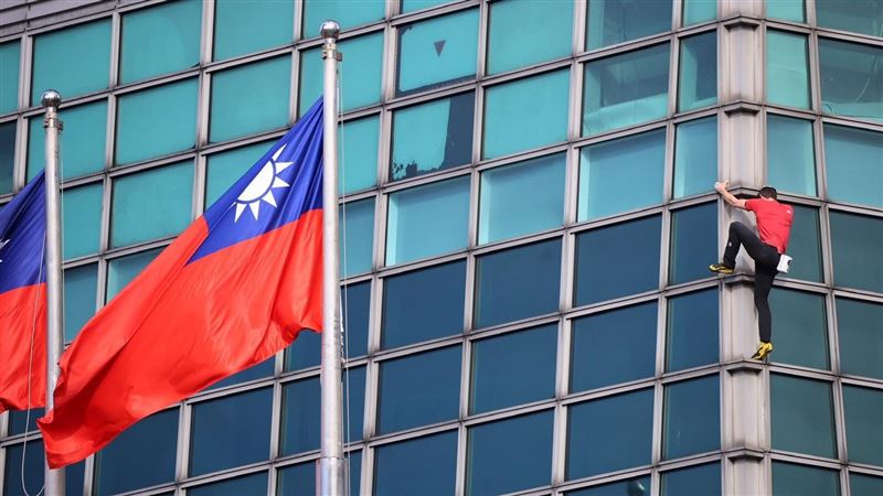 中華民國國旗迎風飄揚，一旁則是身穿紅色T恤、專注攀爬的艾力克斯．霍諾德，這一幕讓很多人很感動。（圖／記者鄭孟晃攝影）