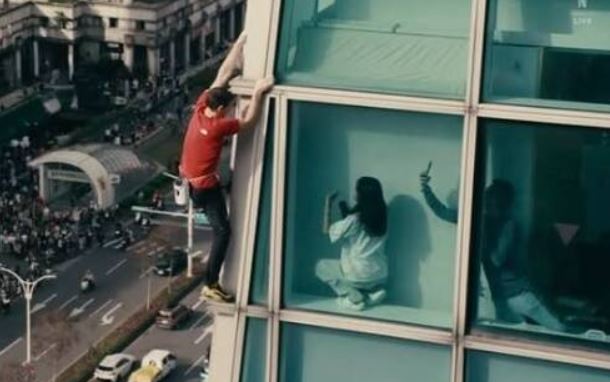 霍諾德在攀爬過程中，網友發現，一名女子蹲在室內近距離拍攝。（圖／翻攝自Netflix直播）