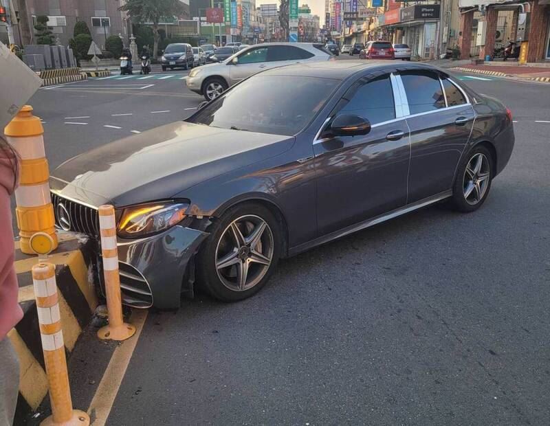 黑色賓士車疑未依標線弧度轉彎，撞上行人庇護島。（圖／翻攝畫面）