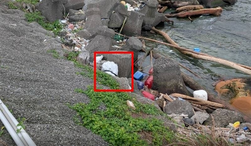 一只不明白色防水麻布袋漂流至「駱駝峰」旁岸際。（圖／翻攝畫面）