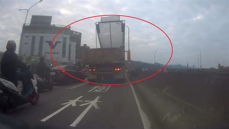 砂石車行經擺接堡路時，因車網架未收，導致紅綠燈號誌桿被勾住扯斷。（圖／翻攝畫面）