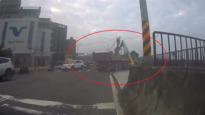 砂石車行經擺接堡路時，因車網架未收，導致紅綠燈號誌桿被勾住扯斷。（圖／翻攝畫面）