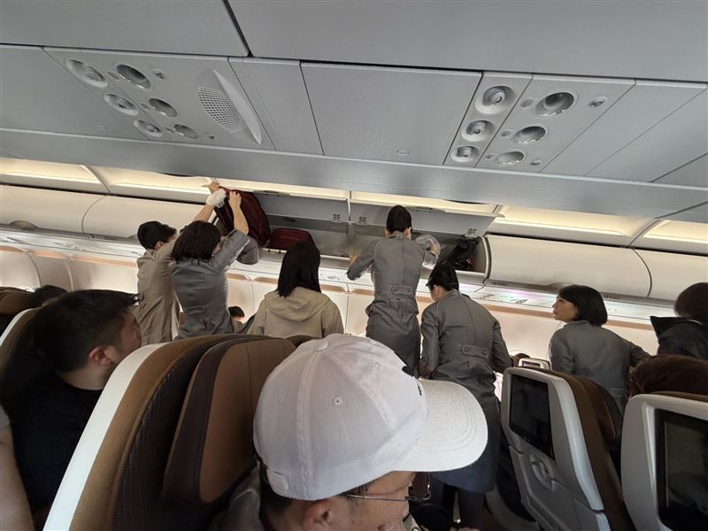 吳姓網友搭機時，目睹行李架上灑水事件，多名空服員趕緊處理。（圖／翻攝自Threads @zaxs96）