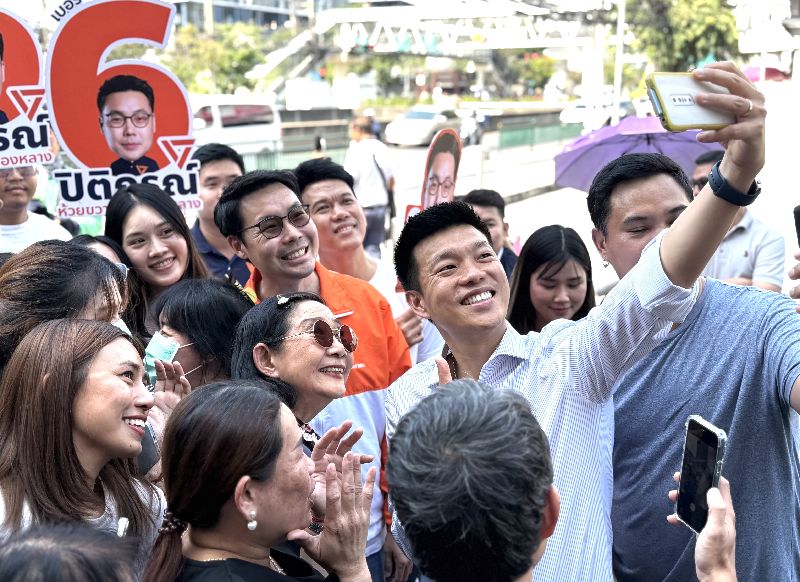 泰國人民黨總理候選人納塔彭與民眾自拍泰國2月8日舉行大選，最新民調顯示，被視為代表年輕世代及改革派的人民黨最受選民青睞，而該黨首席總理候選人納塔彭的支持率也以29.08%位居第一。圖為納塔彭28日在曼谷市場拜票，持手機與選民自拍。中央社記者李宗憲曼谷攝