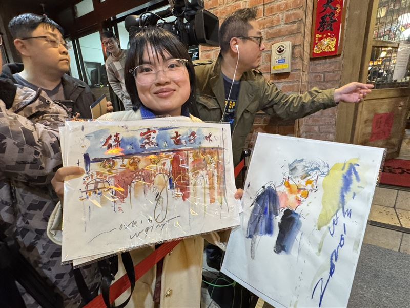 輝達執行長黃仁勳今晚在「磚窯」餐廳宴客,吸引大批粉絲包圍。現場一位街頭速寫畫家吳沁頤,自備板凳在喧鬧中即席作畫,以驚人速度捕捉黃仁勳神韻。她聽從《三立新聞網》記者的「戰略建議」調整卡位動線,果然成功等到黃仁勳現身互動,順利在剛完成的畫作上獲得親筆簽名,圓滿達成心願。(圖/記者余國棟攝影)