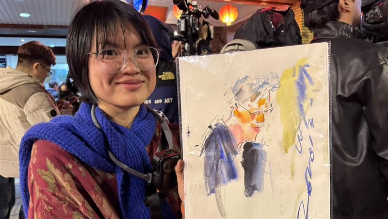 輝達執行長黃仁勳今晚在「磚窯」餐廳宴客,吸引大批粉絲包圍。現場一位街頭速寫畫家吳沁頤,自備板凳在喧鬧中即席作畫,以驚人速度捕捉黃仁勳神韻。她聽從《三立新聞網》記者的「戰略建議」調整卡位動線,果然成功等到黃仁勳現身互動,順利在剛完成的畫作上獲得親筆簽名,圓滿達成心願。(圖/記者余國棟攝影)