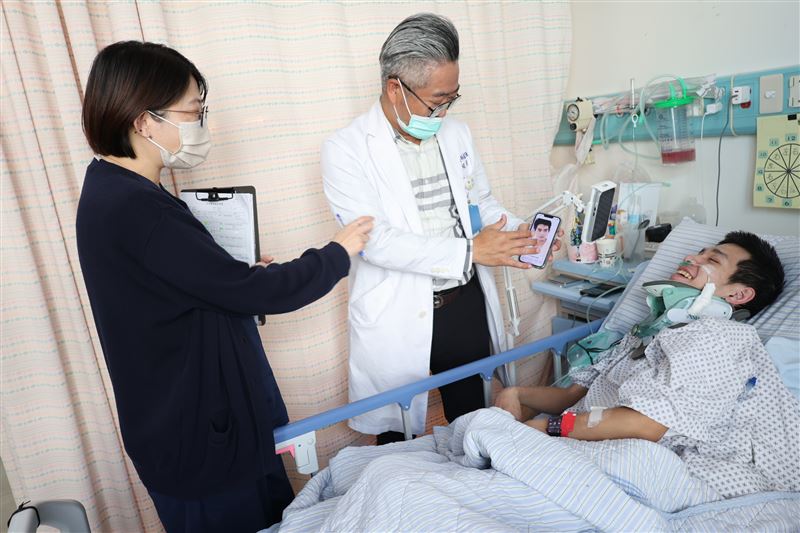 彰化醫院神經外科主任趙紹清（中）逗笑施姓男大生(右)。（圖／彰化醫院提供）
