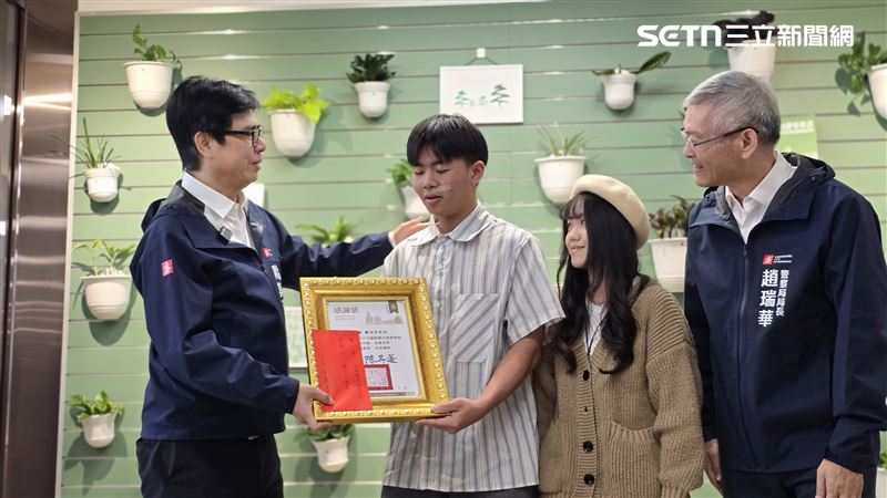 男大生穿著一件藍白線條襯衫，從陳其邁手中接過獎狀，是堵上性命的證明。（圖／翻攝畫面）