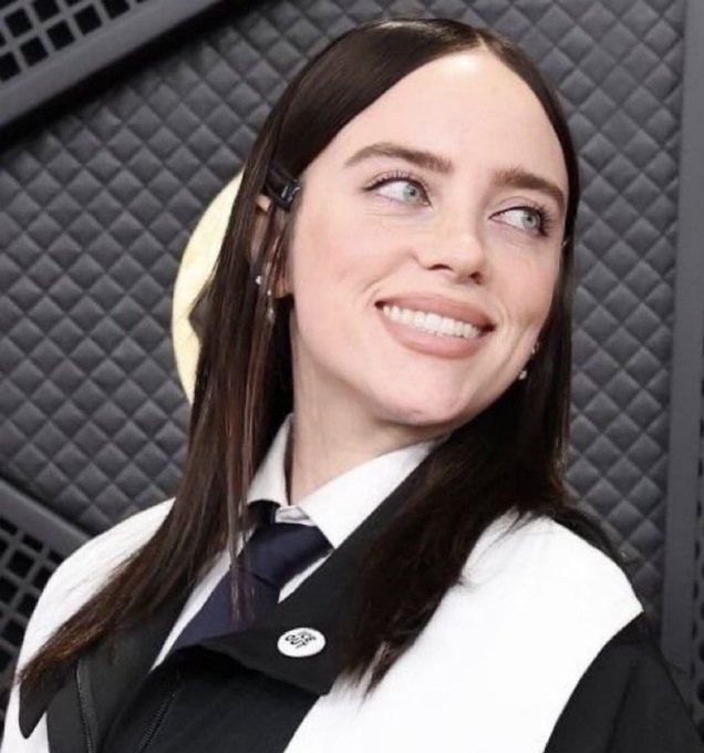 怪奇比莉別上「ICE OUT」胸章,致詞時用髒話抨擊執法行為,一度遭到消音。(圖/翻攝自X平台 @OliLondonTV)