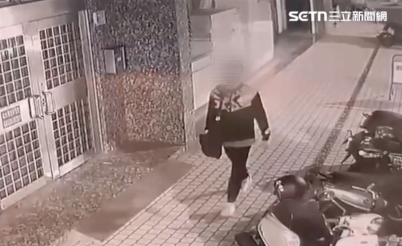陳男走在人行道上，時不時翻開包包看個幾眼，步伐冷靜，尋找下手目標。（圖／翻攝畫面）