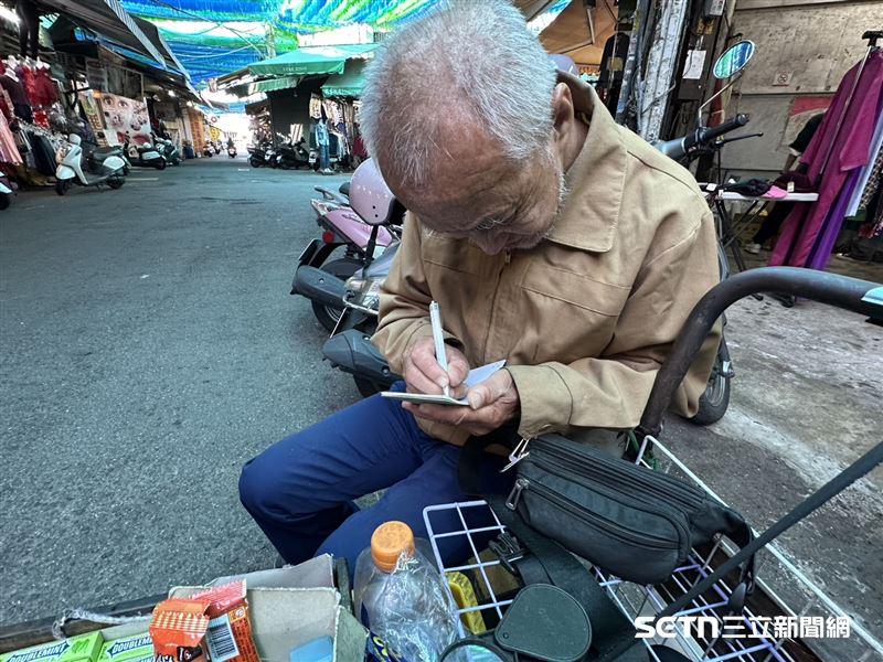 劉阿公其實不識字，但當記者詢問他叫什麼名字時，阿公發現記者聽不懂，他二話不說暖心地拿出紙筆，嘗試寫出自己的名字，不會的字，他就透過周邊剛好有的字，用手比給記者看。（圖／記者張雅筑攝）