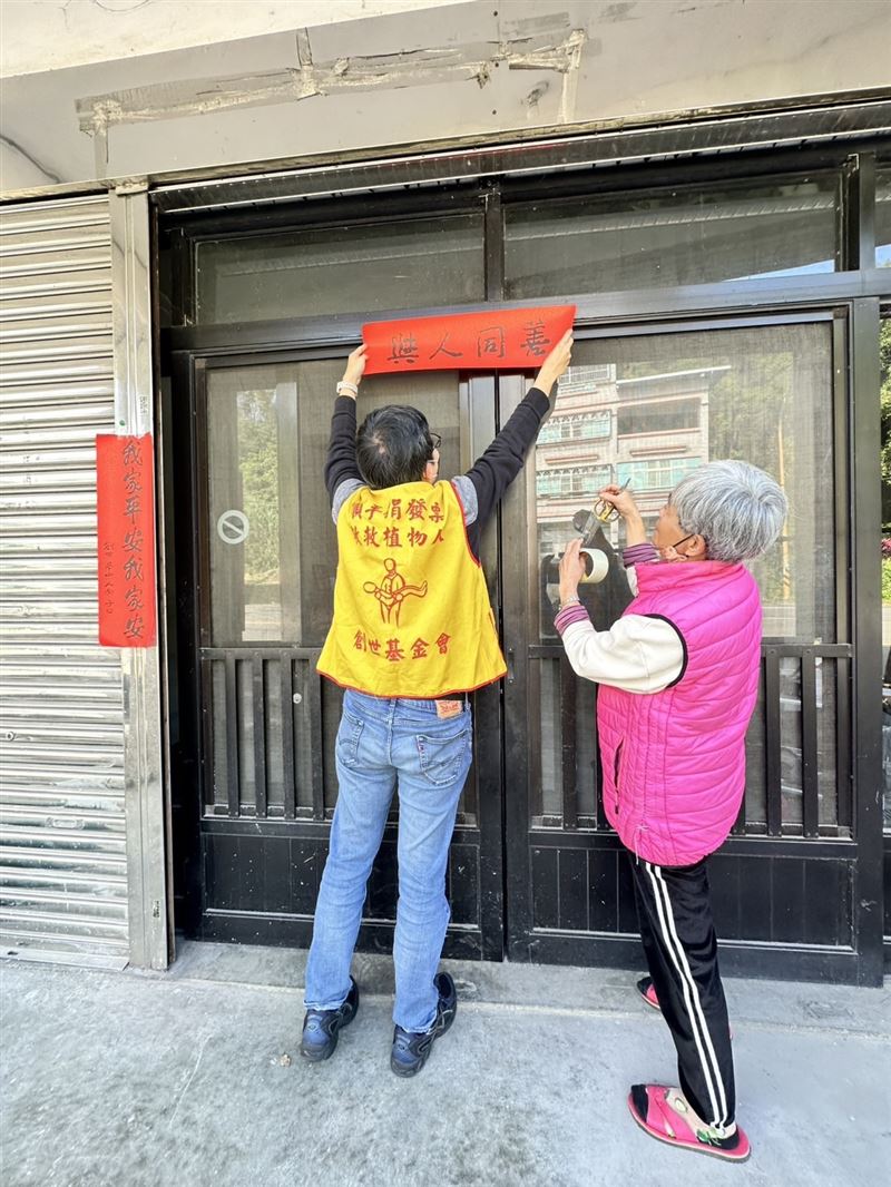 創世基金會桃園分院偕同凱基人壽員工一同將年禮及紅包親送給植物人家屬，並貼上吉祥喜氣的春聯。（圖／桃園電子報提供）