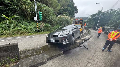 基隆小客車打滑失控！「騎上護欄」卡半空