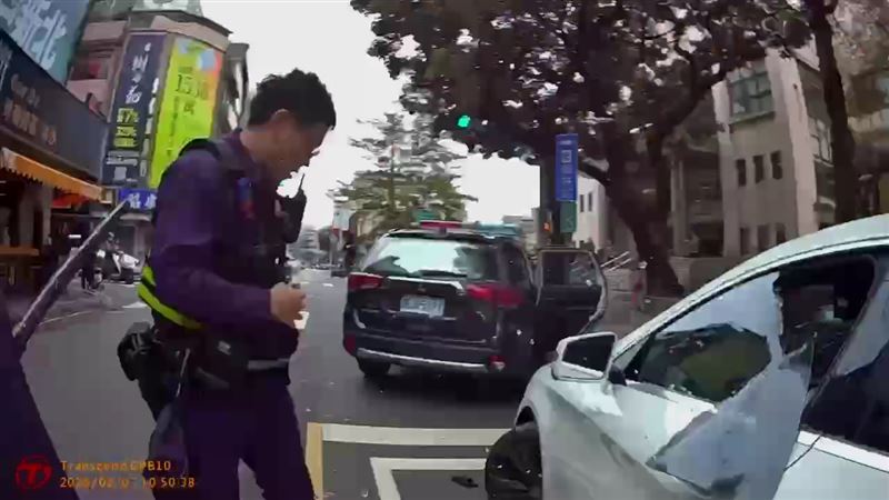 白色賓士車違規遭員警盤查，駕駛拒檢倒車後再往前加速逃逸，員警破窗制止。（圖／翻攝畫面）