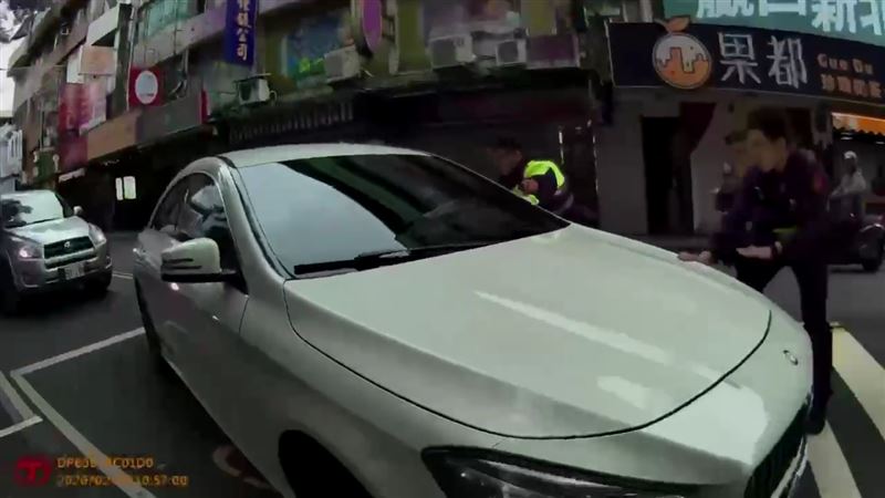白色賓士車違規遭員警盤查，駕駛拒檢倒車後再往前加速逃逸。（圖／翻攝畫面）
