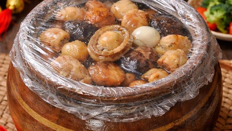 年菜如佛跳牆、清蒸魚加熱時，常用保鮮膜包裹，保鮮膜遇油脂、高溫易融出塑化劑，長期攝取恐影響男性生殖健康與荷爾蒙。（圖／AI製圖）