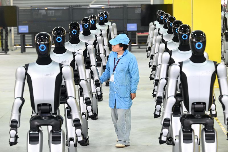 中國人形機器人市場大幅成長，圖為2025年12月26日，廣西柳州第1000台工業人形機器人Walker S2下線，工人正在檢查。（中新社提供）