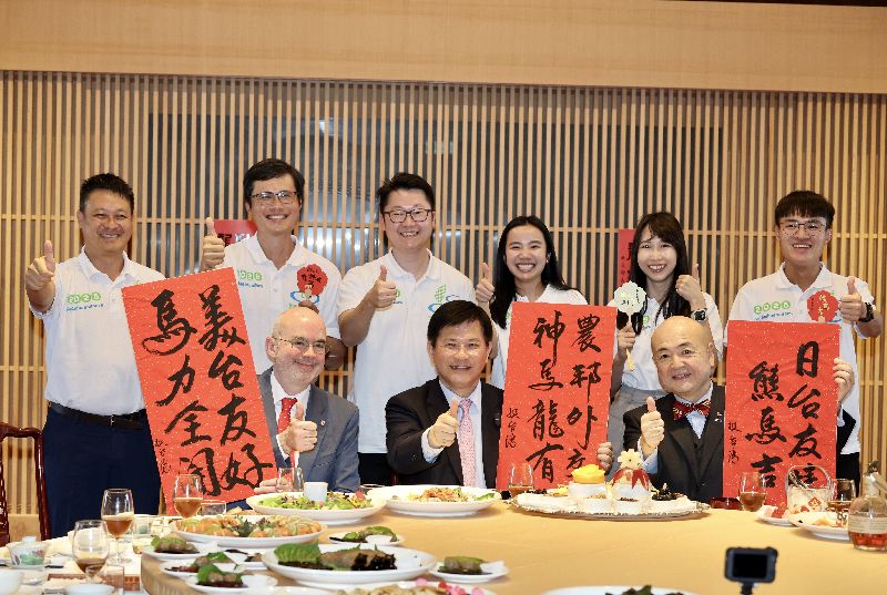 外交部長林佳龍（前排中）日前在外交部擺桌請團圓飯，農業青年大使不僅親自下廚準備佳餚，還特地請書法家客製化3幅春聯，期許台美日關係堅實。（圖／中央社）