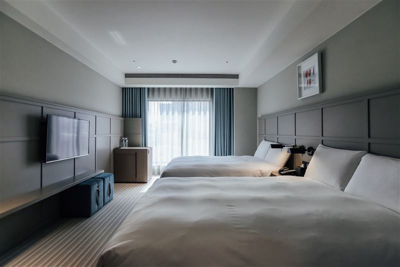 「Greet Inn喜迎旅店」客房簡約柔和的色調搭配大面採光落地窗營造明亮放鬆的氛圍，讓走春奔波後能徹底卸下疲憊。（圖／Booking.com提供）