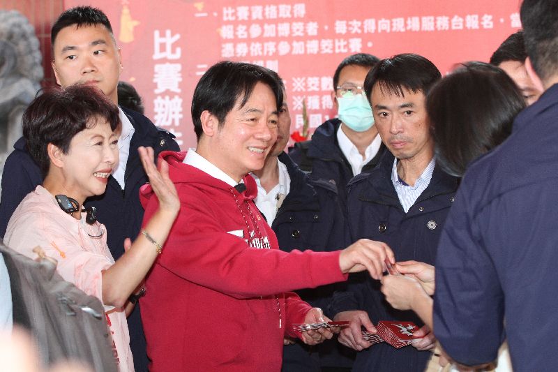 總統賴清德（前左2）17日下午到台南麻豆代天府發放福袋，吸引大批民眾提早到現場排隊領取