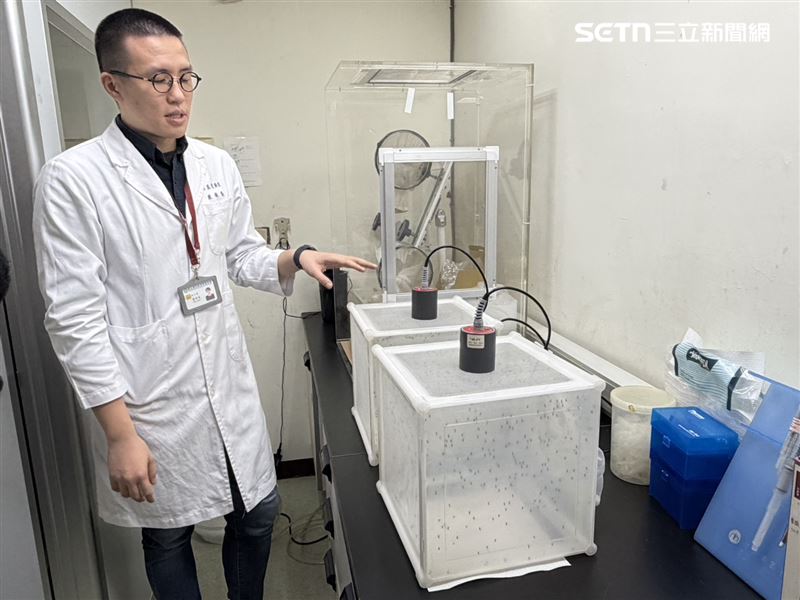 蔡奕戎說明現採行人工餵血系統，將石蠟封膜拉薄模擬皮膚套在加熱裝置上形成空間倒入豬血。（圖／記者簡浩正攝影）