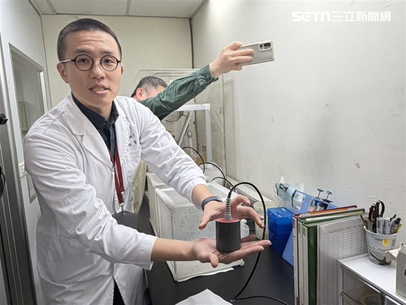 蔡奕戎說明現採行人工餵血系統，將石蠟封膜拉薄模擬皮膚套在加熱裝置上形成空間倒入豬血。（圖／記者簡浩正攝影）