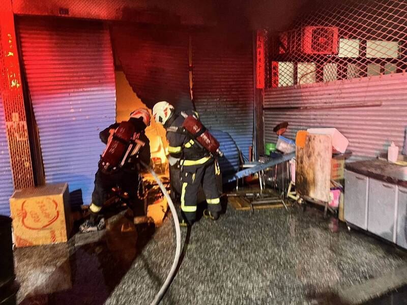 消防人員撬開一樓鐵捲門。（圖／翻攝畫面）