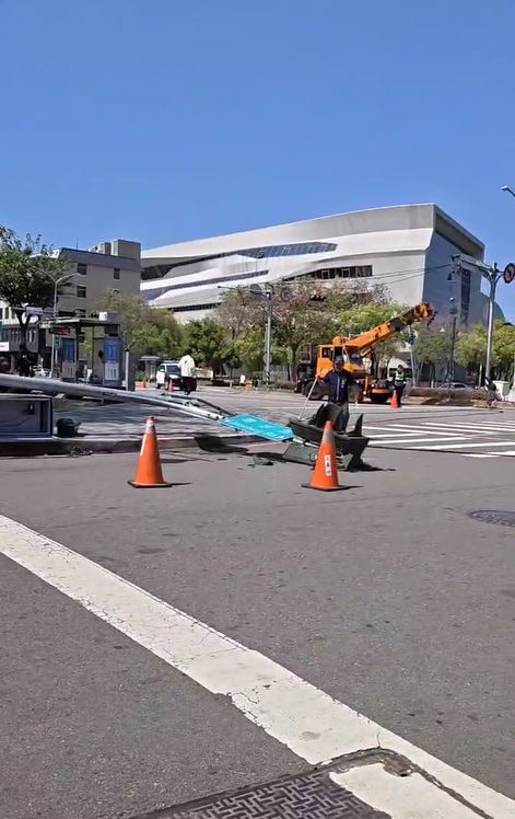 一輛大型吊車行經東區建成路口，因未收起吊臂，勾到電線導致號誌桿被拉斷。(圖／翻攝畫面)