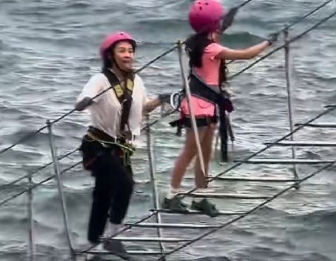 旅程亮點之一是章子怡陪女兒挑戰海上懸崖攀岩，女兒甚至淡定回頭催促媽媽加快速度。（圖／翻攝自新浪）