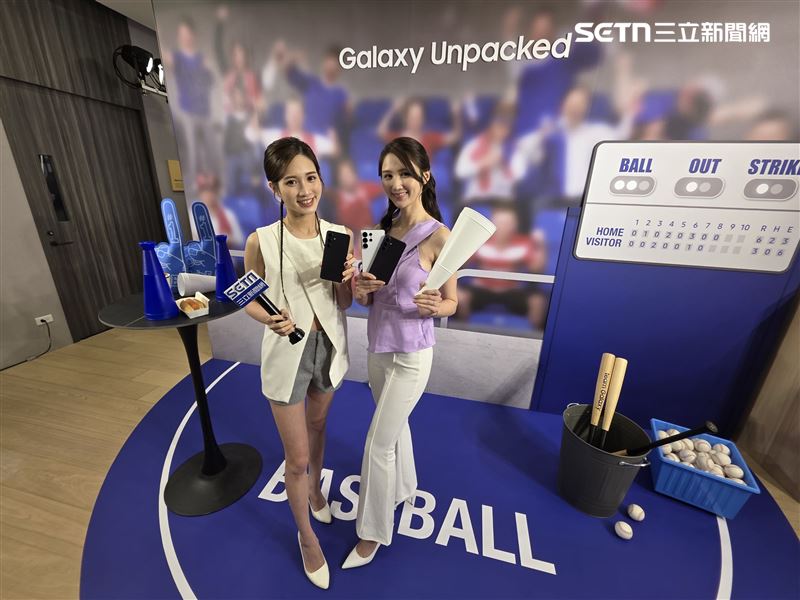 三星Galaxy Unpacked活動現場設有棒球主題互動拍照區,模特兒手持Galaxy S26系列新機,主打運動場景下的防震錄影與動態拍攝表現。(圖/記者李宜樺攝影)