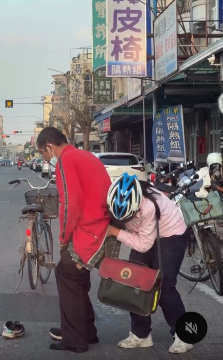 一名疑似失智的男子因褲子脫落、鞋子掉落，無人敢上前協助。 此時，女高中生毫不猶豫地停下車，彎腰替男子整理衣褲並穿好鞋子。（圖／翻攝ada_330627）