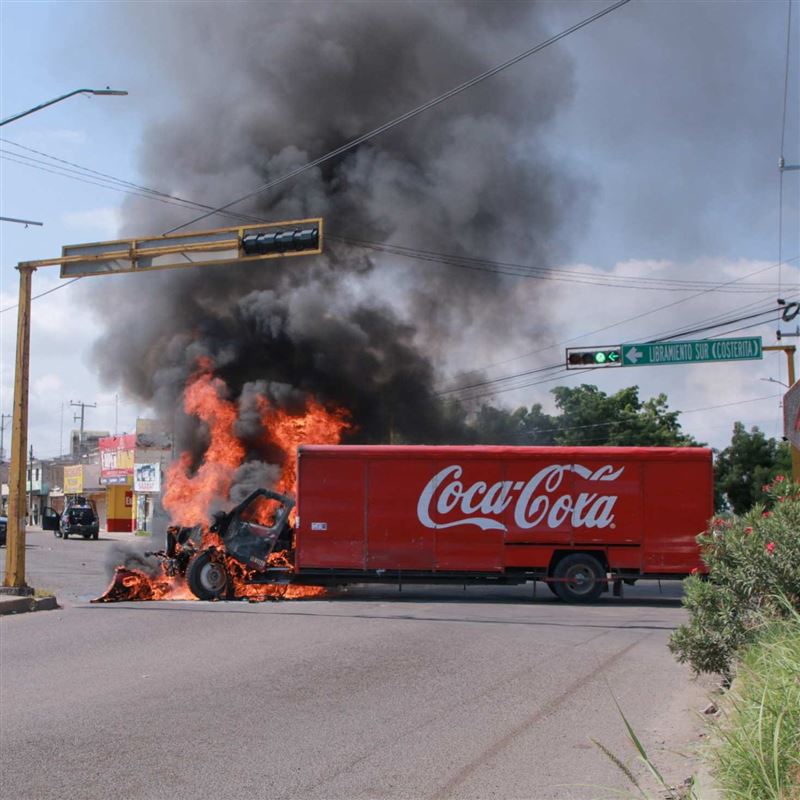 墨西哥城市庫利亞坎深陷幫派火拚的暴力浪潮,路上可見運送可樂的卡車被縱火燃燒,黑煙竄天。(圖/翻攝自X平台 @BowTiedPassport)