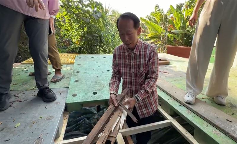 挪開塑膠棧板，掀開底下的帆布，全是廢棄木材、碎磁磚等裝潢廢棄垃圾。(圖／翻攝畫面)