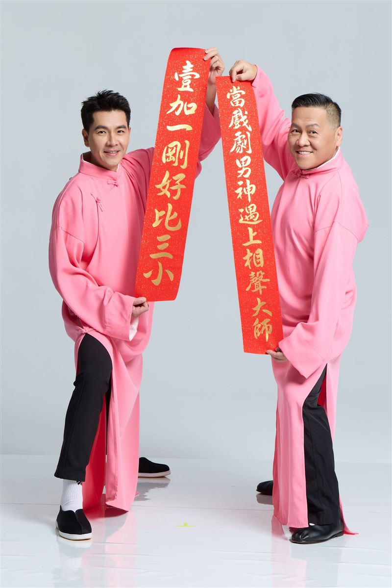朱德剛（右）與王傳一（左）手持寫著「當戲劇男神遇上相聲大師」及「壹加一剛好比三小」的紅色春聯。（圖／嚞娛樂提供）